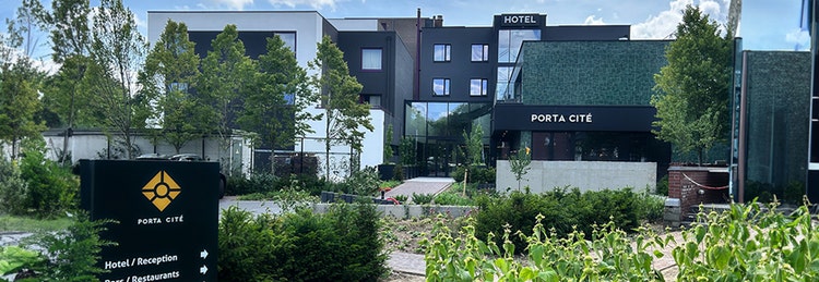 A hotel sign prominently displayed in front of a building, indicating the establishment's name and welcoming guests.
